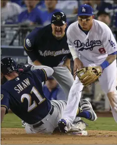  ??  ?? Milwaukee Brewers’ Travis Shaw slides into third after hitting a triple during the sixth inning of Game 3 of the National League Championsh­ip Series baseball game against the Los Angeles Dodgers on Monday, in Los Angeles. AP PHOTO/MARK J. TERRILL