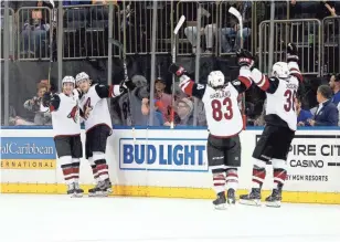  ??  ?? The Coyotes’ Christian Dvorak, second from left, reacts with his teammates after scoring the winning goal against the Rangers in overtime in New York.