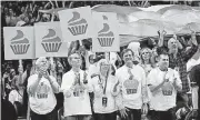  ?? [AP PHOTO] ?? Fans wear cupcake T-shirts and hold cupcake signs during Saturday night’s game between the Thunder and Golden State Warriors in Chesapeake Energy Arena. Warriors star Steph Curry gave an OKC fan a Golden State practice T-shirt in exchange for a cupcake...