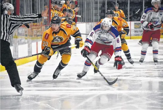  ?? TINA COMEAU PHOTOS ?? Yarmouth's Michael Johnson and Summerside's Zach Biggar watch as the puck hits the boards during first-period action in Yarmouth on Jan. 11.