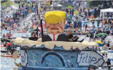  ?? FOTO: DPA ?? Ein Themenboot, das US-Präsident Donald Trump in einem überdimens­ionalen Fettnapf zeigt, war beim Nabada am Montag viel beachtet.