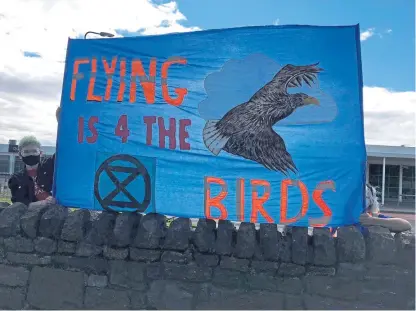  ?? Pictures: Extinction Rebellion. ?? Climate activists hold up a banner outside Dundee Airport on Saturday.