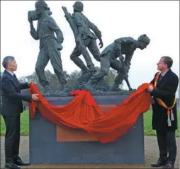  ?? DE YONGJIAN / CHINA NEWS SERVICE ?? Qu Xing, Chinese ambassador to Belgium, unveils a statue to commemorat­e the Chinese laborers of World War I, with Poperinge Mayor Christof Dejaegher, on Wednesday in Belgium.