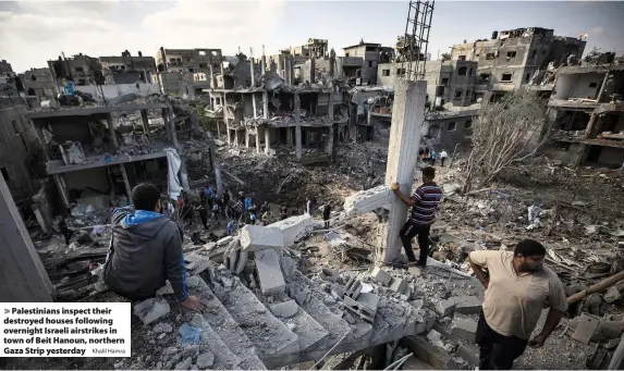  ?? Khalil Hamra ?? > Palestinia­ns inspect their destroyed houses following overnight Israeli airstrikes in town of Beit Hanoun, northern Gaza Strip yesterday