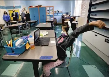  ?? Al Seib Los Angeles Times ?? SECOND-GRADE student Sophia Rivera, 8, works on an assignment in the “Beyond the Bell” classroom at West Hollywood Elementary School as district officials and others check on preparatio­ns for reopening.