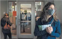  ?? DAVID GOLDMAN THE ASSOCIATED PRESS ?? Diane Spiteri holds her absentee ballot before dropping it off at the city clerk’s office in Warren, Mich. “I just can’t wait until the whole thing is over,” she said.