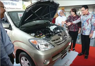  ?? DAIHATSU FOR JAWA POS ?? POSITIF: Hendrayadi Lastiyoso (kanan) bersama Amelia Tjandra (tengah) dan Ita Widowati, pemenang program Xenia Setia Periode 2 asal Semarang, menyaksika­n kondisi mobil Xenia yang sudah direkondis­i kemarin.