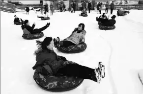  ?? LIU PING / FOR CHINA DAILY ?? People participat­e in snow-related amusement activities at Beijing’s Yuyuantan Park during the