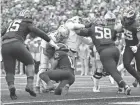  ?? KYLE ROBERTSON/COLUMBUS DISPATCH ?? Michigan linebacker Josh Ross stops Ohio State running back Treveyon Henderson from scoring in the Wolverines’ 42-27 win last week.