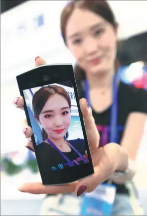  ?? PROVIDED TO CHINA DAILY ?? A staff member displays her selfie edited by the photo app Meitu at an internatio­nal software expo in Beijing on May 27, 2015.