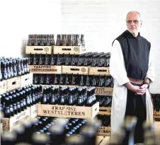  ??  ?? Brother Godfried poses by the crates full of Westvleter­en beer at the shop of the Saint-Sixtus abbey, in Westvleter­en.