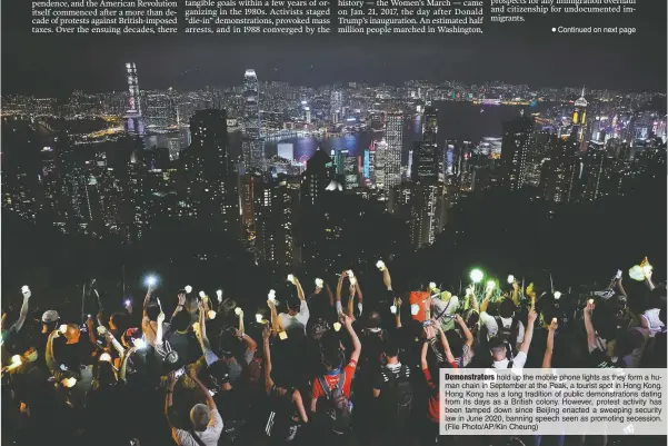  ??  ?? Demonstrat­ors hold up the mobile phone lights as they form a human chain in September at the Peak, a tourist spot in Hong Kong. Hong Kong has a long tradition of public demonstrat­ions dating from its days as a British colony. However, protest activity has been tamped down since Beijing enacted a sweeping security law in June 2020, banning speech seen as promoting secession. (File Photo/AP/Kin Cheung)