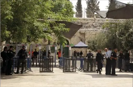  ?? MAHMOUD ILLEAN, THE ASSOCIATED PRESS ?? Israeli border police officers stand near newly installed cameras and metal detectors at the entrance to the Al Aqsa Mosque compound, in Jerusalem’s Old City on Sunday. Israel installed the cameras Sunday at the entrance to a sensitive Jerusalem holy...