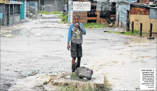  ?? Picture: MARK ANDREWS ?? HUGE DELUGE: A youngster from Nompumelel­o, in Beacon Bay, plays on top of an overflowin­g drain during yesterday’s rain