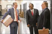  ?? RALPH BARRERA / AMERICAN-STATESMAN ?? Attorneys Bill Bunch (left) and Fred Lewis (right) talk with their client Nelson Linder, who sued the city over CodeNext, the rewrite of Austin’s developmen­t code.