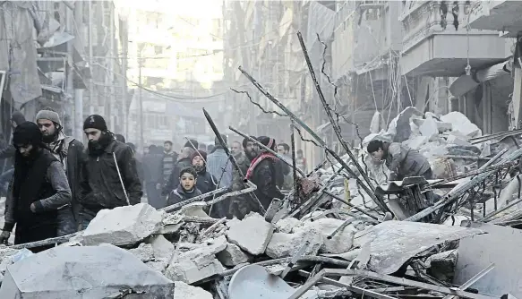  ?? Foto: Reuters ?? Město zkázy Syřané v opozicí kontrolova­né části Aleppa procházejí mezi troskami budov poté, co udeřily bombardéry sil prezidenta Bašára Asada.