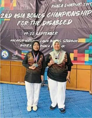  ??  ?? Dynamic duo: Rattna Aizah Mohd Idris (left) and Suraya Hamzani posing with their medals after winning the women’s pairs B8 (physical disabiliti­es) in the second Asia Lawn Bowls Championsh­ips in Bukit Kiara yesterday.