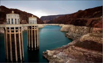  ?? AP Photo/John Locher ?? In this 2014 file photo, lightning strikes over Lake Mead near Hoover Dam that impounds Colorado River water at the Lake Mead National Recreation Area in Arizona.