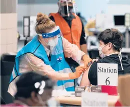  ?? ERIC GAY/AP ?? A health care worker administer­s a COVID-19 vaccinatio­n Monday at the new Alamodome COVID-19 vaccine site in San Antonio. Officials say the site is providing 1,500 vaccinatio­ns per day as cities and states across the nation are ramping up efforts.