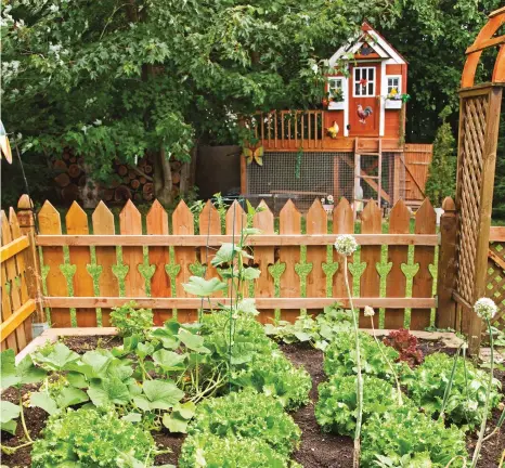  ??  ?? Dans une autre portion de la cour, un potager a été aménagé et entouré d'une clôture en bois, qui présente un motif de coeur entre chaque planche. Cette installati­on a également été pensée dans un esprit champêtre, tout comme le poulailler !