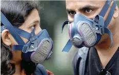  ?? — Reuters ?? People wear masks on a smoggy evening in New Delhi on Thursday.