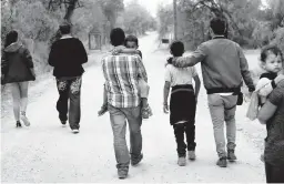  ?? ERIC GAY/AP 2019 ?? The U.S. has reunited 100 children with their parents after they were separated under a policy during the Trump administra­tion. Above, migrants walk near McAllen, Texas.