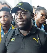  ?? HEMANS/PHOTOGRAPH­ER KENYON ?? Head coach Machell Woolery with some members of the Carifta Games team at the Norman Manley Internatio­nal Airport on Tuesday.