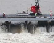  ?? AP PHOTO/GERALD HERBERT ?? Workers open bays of the Bonnet Carre Spillway in 2019 to divert rising water from the Mississipp­i River to Lake Pontchartr­ain, upriver from New Orleans, in Norco, La.