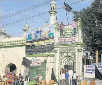  ??  ?? Muslims hoist black flags on a mosque on the 25th anniversar­y of the Babri Masjid demolition in Ayodhya on Wednesday.