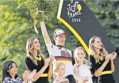  ?? FOTO: IMAGO ?? André Greipel im Trikot des deutschen Meisters bei der Ehrung für seinen Sieg bei der SchlussEta­ppe der Tour de France 2016 in Paris. Neben ihm stehen seine Töchter AnnaSophia (r.) und Luna-Malou.