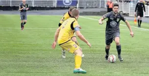  ??  ?? Merthyr’s Corey Jenkins takes on two Hereford defenders