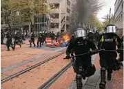  ?? Dave Killen / The Oregonian via Associated Press ?? Police disperse participan­ts in a May Day rally in Portland, Ore. Police said the rally permit was canceled after marchers threw projectile­s at officers.