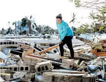  ?? GERALD HERBERT/AP ?? Mishelle McPherson looks for her friend, Agnes Vicari, in the rubble of her home in Mexico Beach. Vicari stayed in her home during the storm.