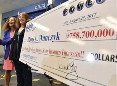  ?? STEVEN SENNE — THE ASSOCIATED PRESS ?? Mavis Wanczyk, of Chicopee, Mass., stands by a poster of her winnings during a news conference where she claimed the $758.7 million Powerball prize at Massachuse­tts State Lottery headquarte­rs, Thursday in Braintree, Mass. Officials said it is the...