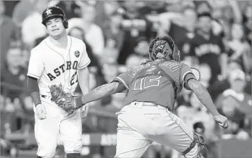  ?? Bob Levey Getty Images ?? JOSE ALTUVE of Houston is tagged out by the Angels’ Martin Maldonado after being caught in a rundown.