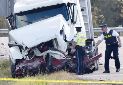  ?? JOHN RENNISON, THE HAMILTON SPECTATOR ?? OPP officers look at the front of the transport truck that collided head-on with another vehicle on Highway 6 Thursday morning.