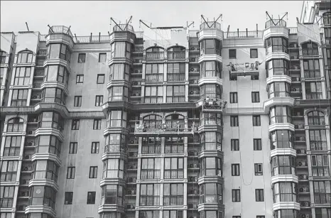  ?? AFP ?? Builders work at a housing project in Beijing in April.