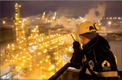  ?? Bloomberg News/ANDREY RUDAKOV ?? A worker monitors a unit of the Novokuibys­hevsk oil refinery in the Samara region of Russia. Russia has reduced the amount of oil it pumps each day.