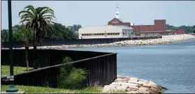  ?? AP Photo/David J. Phillip ?? Seawall: A seawall, which will be increased in size, is shown along the banks near downtown Thursday, July 26, 2018, in Port Arthur, Texas. The oil industry wants the government to help protect some of its facilities on the Texas Gulf Coast against the effects of global warming. One proposal involves building a nearly 60-mile “spine” of flood barriers to shield refineries and chemical plants. Many Republican­s argue that such projects should be a national priority. But others question whether taxpayers should have to protect refineries in a state where top politician­s still dispute whether climate change is real.