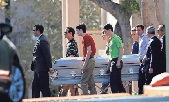  ??  ?? Pallbearer­s carry the casket of Scott Beigel in Boca Raton, Fla., on Sunday. Beigel was a teacher at Marjory Stoneman Douglas High School. GERALD HERBERT/AP