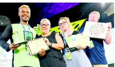  ??  ?? Claye Edou from Cameroon collects his award from Jacqueline Lynch-Stewart from the OPM and Marie-Eve Lacelle of Toon Boom Annimation and Bill Lindsay of Wacom Technology Corporatio­n.