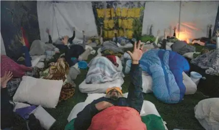  ?? JESSIE WARDARSKI/AP 2022 ?? Lorenzo Gonzales, center, and other retreat participan­ts reach skyward during a three-night ayahuasca ceremony in Hildale, Utah.