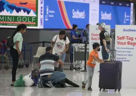  ?? David Zalubowski, The Associated Press ?? Travelers sift through luggage before approachin­g the self checkin kiosks at the Southwest Airlines ticketing counter in Denver Internatio­nal Airport on July 5.