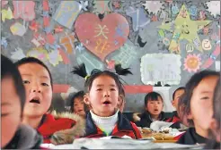  ?? PHOTOS BY YANG WENBIN / XINHUA ?? Left: Students from Yina township, Weining county in Guizhou province attend class. The town has received poverty aid and the average income of farmers has increased as a result. Right: Farmers from Wanghutun village, Taijiang county in Guizhou, wear...