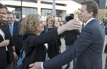  ?? Associated Press ?? Attorneys Linda Singer and Mark Lanier hug outside the federal courthouse in Cleveland on Monday. Both Ms. Singer and Mr. Lanier are the plaintiffs’ attorneys in a suit involving the nation’s three dominant drug distributo­rs and a big drugmaker.