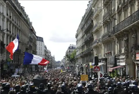  ?? Adrienne Surprenant/Associated Press ?? Protesters wave French flags during a demonstrat­ion Saturday in Paris. Demonstrat­ors gathered in several cities in France to protest against the COVID-19 pass, which grants vaccinated individual­s greater ease of access to venues.