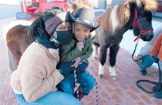  ?? ROBERT WILLETT/RALEIGH NEWS & OBSERVER ?? Caitlin Gooch, founder of Saddle Up and Read, with 3-year-old Sevyn Hodge during a fundraiser and book drive Dec. 19 in Wendell, North Carolina.