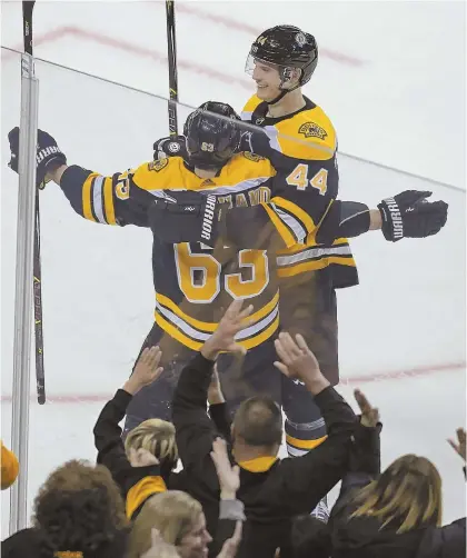  ?? STAFF PHOTO BY JOHN WILCOX ?? GO CRAZY, FOLKS: Bruins winger Brad Marchand (63) is congratula­ted on his overtime game-winner by defenseman Nick Holden (44) while the Garden crowd roars after last night's victory against Montreal.