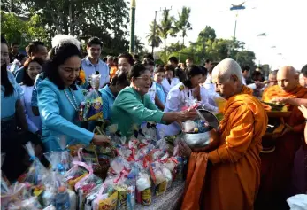  ??  ?? QUEEN’S BIRTHDAY CELEBRATIO­NS: People offer alms to Buddhist monks to celebrate the 86th birthday of Thai Queen Sirikit of the late King Bhumibol Adulyadej in Narathiwat yesterday. — AFP photo