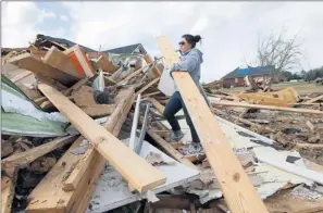  ?? By Brennen G. Smith, The Decatur (Ala.) Daily, via AP ?? Extending into the South: Karly Gale, part of a relief group from Xavier University, helps with recovery efforts March 4 in Limestone County, Ala., after tornadoes uprooted trees and flattened buildings.